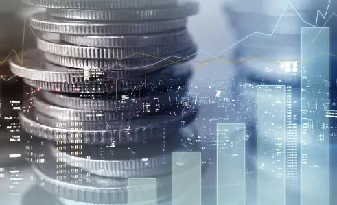 Stack of coins with an overlay of a city skyline and bar graph